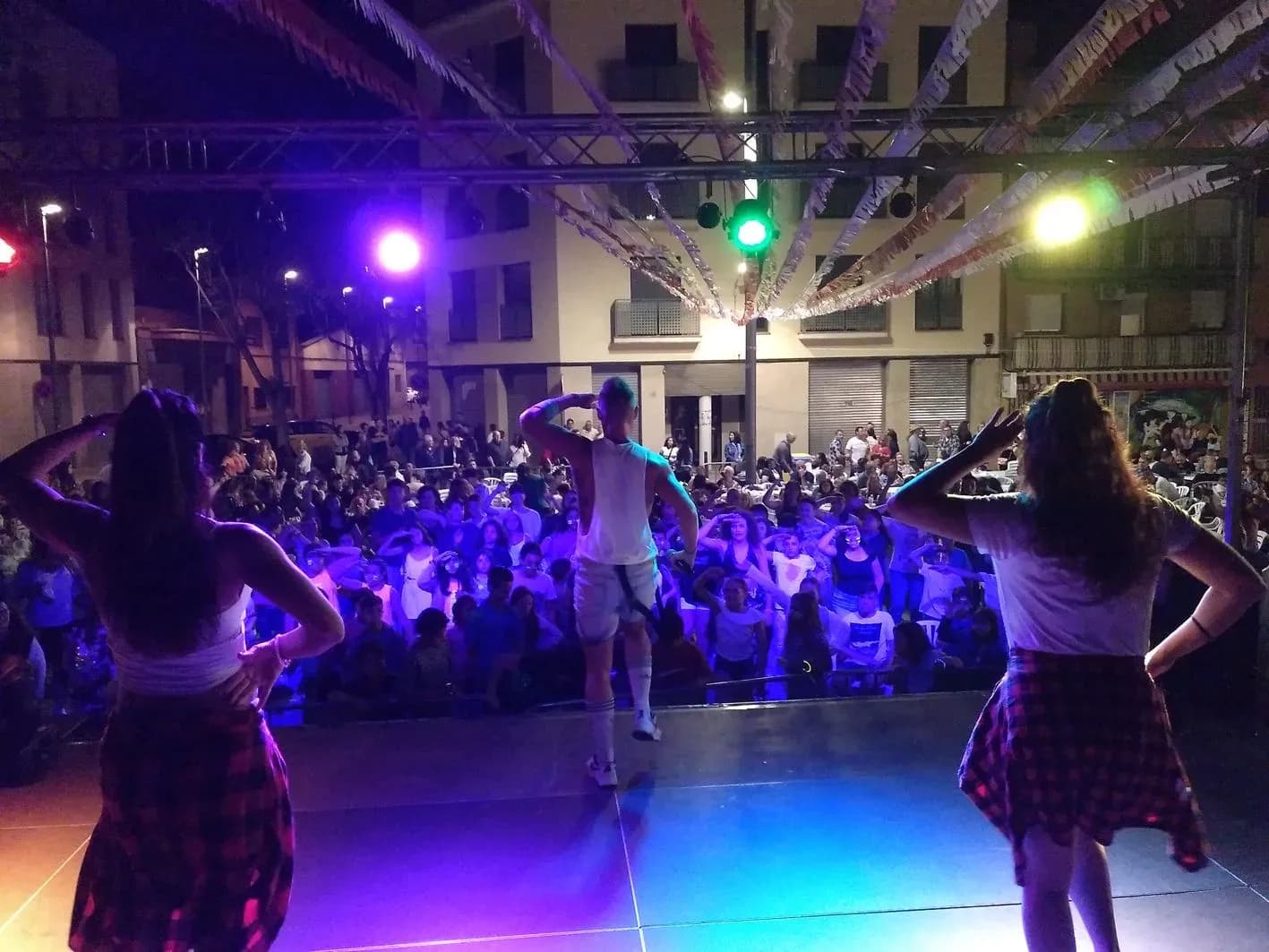 Animadora infantil con gafas violetas, coletas y micro vincha interactuando con un niño en fiesta de cumpleaños