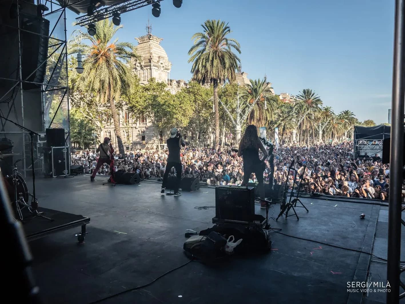 Big Mouthers en directo sobre escenario al aire libre con palmeras de fondo y gran público al sol en festival de Barcelona