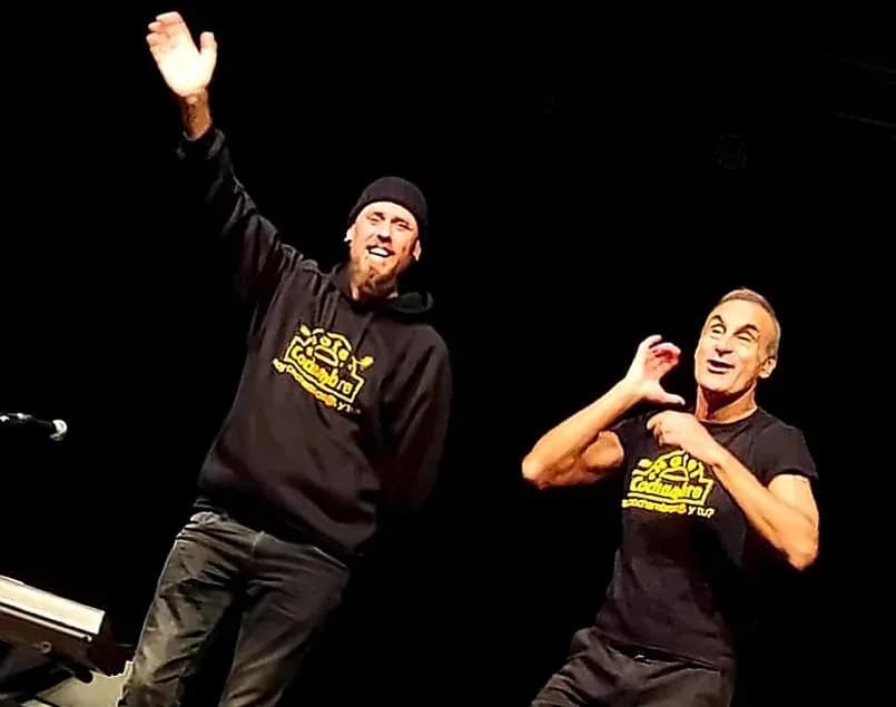 Bajista de Commando cantando con cazadora de cuero y camiseta de Ramones tocando bajo blanco en directo