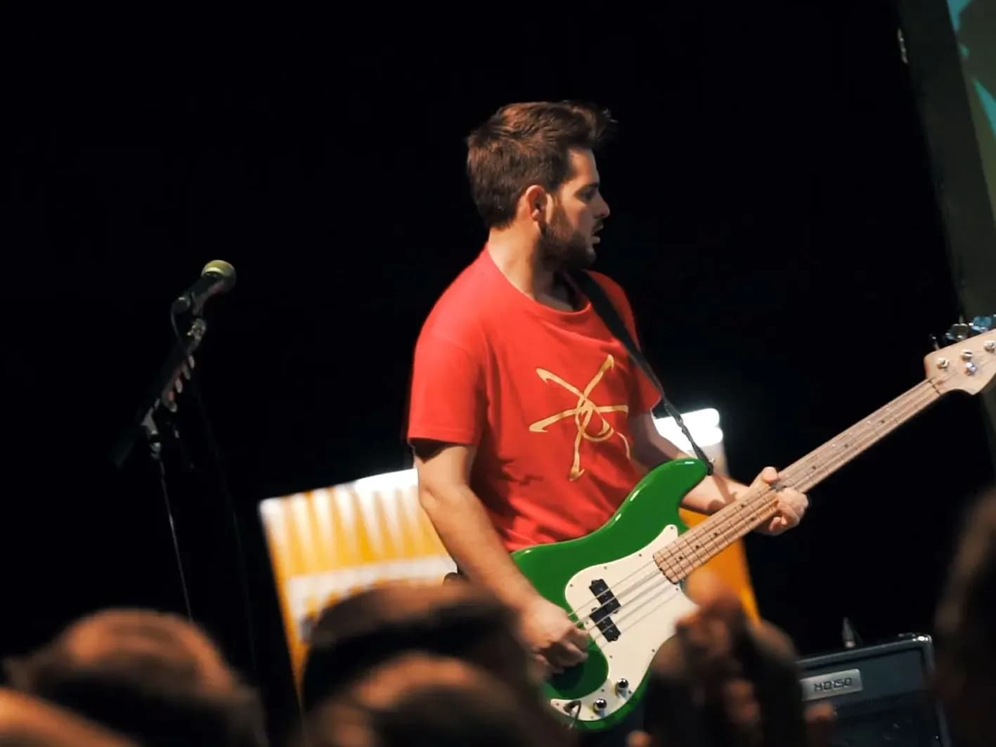 Guitarrista de Els Kremats con chaqueta azul, pajarita roja y gafas tocando solo de guitarra eléctrica en concierto