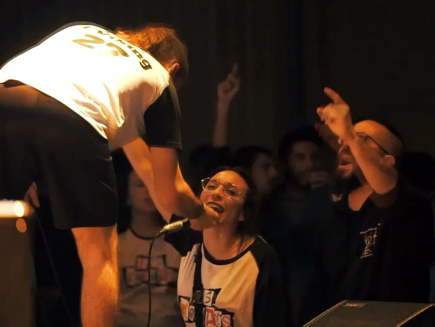 Vocalista de Els Kremats bajando del escenario para cantar con el público y otra integrante coreando junto al teclado