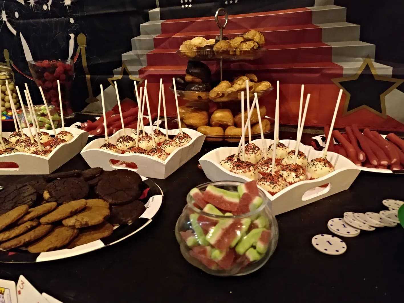 Mesa de aperitivos infantil con cake pops galletas y gominolas decorada para fiesta tematica