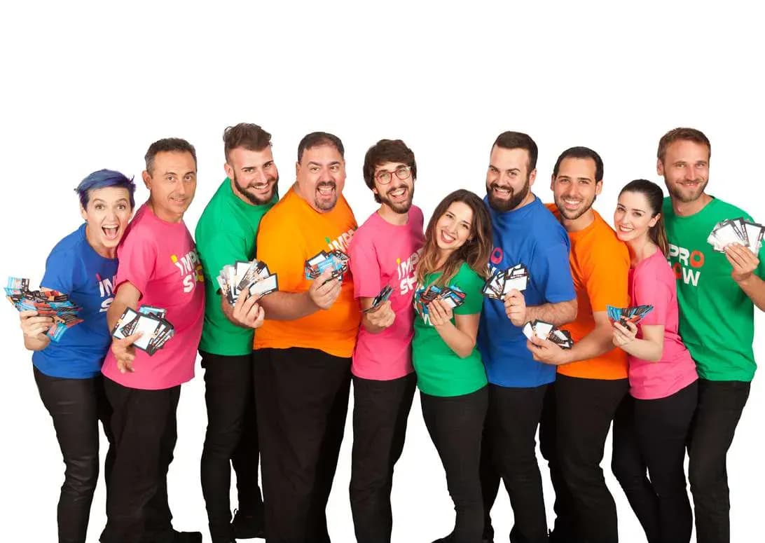 Elenco de Impro Show posando con camisetas de colores vivos sosteniendo flyers sobre fondo blanco