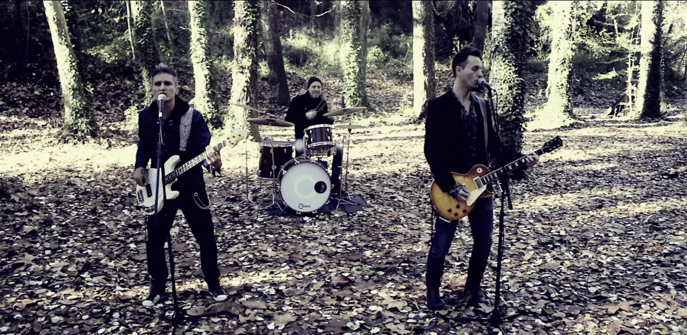 Banda Mindtrick grabando videoclip en bosque con bajista, baterista y guitarrista entre arboles y hojas secas