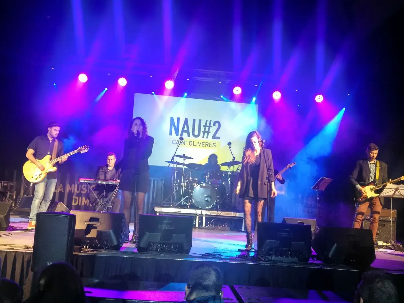 Grupo Movie Band en directo en sala con dos vocalistas, bajo, guitarra, teclado y bateria con luces azules