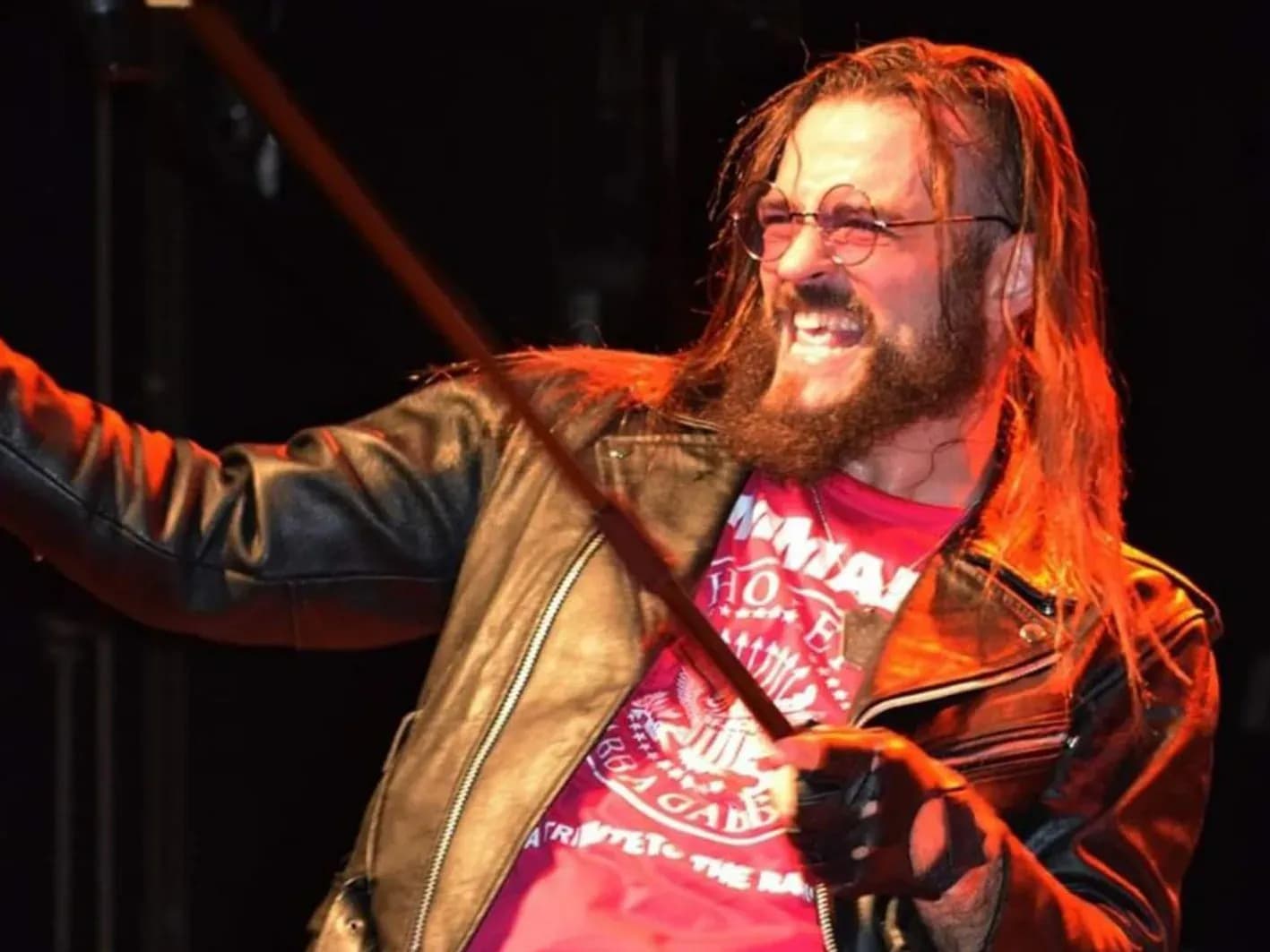 Vocalista pelirrojo de Commando con camiseta tributo Ramones y chaqueta de cuero cantando junto al batería en concierto